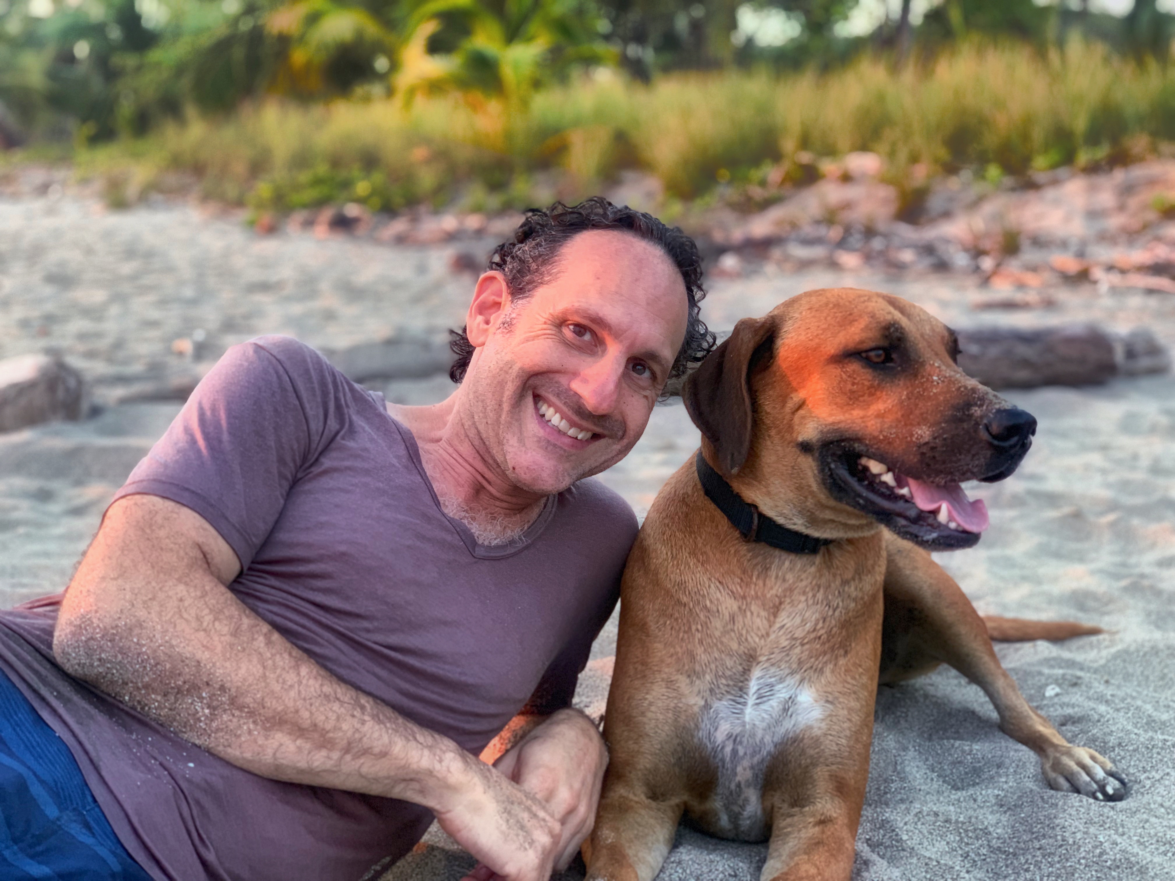 Steven with a dog at golden hour on the beach