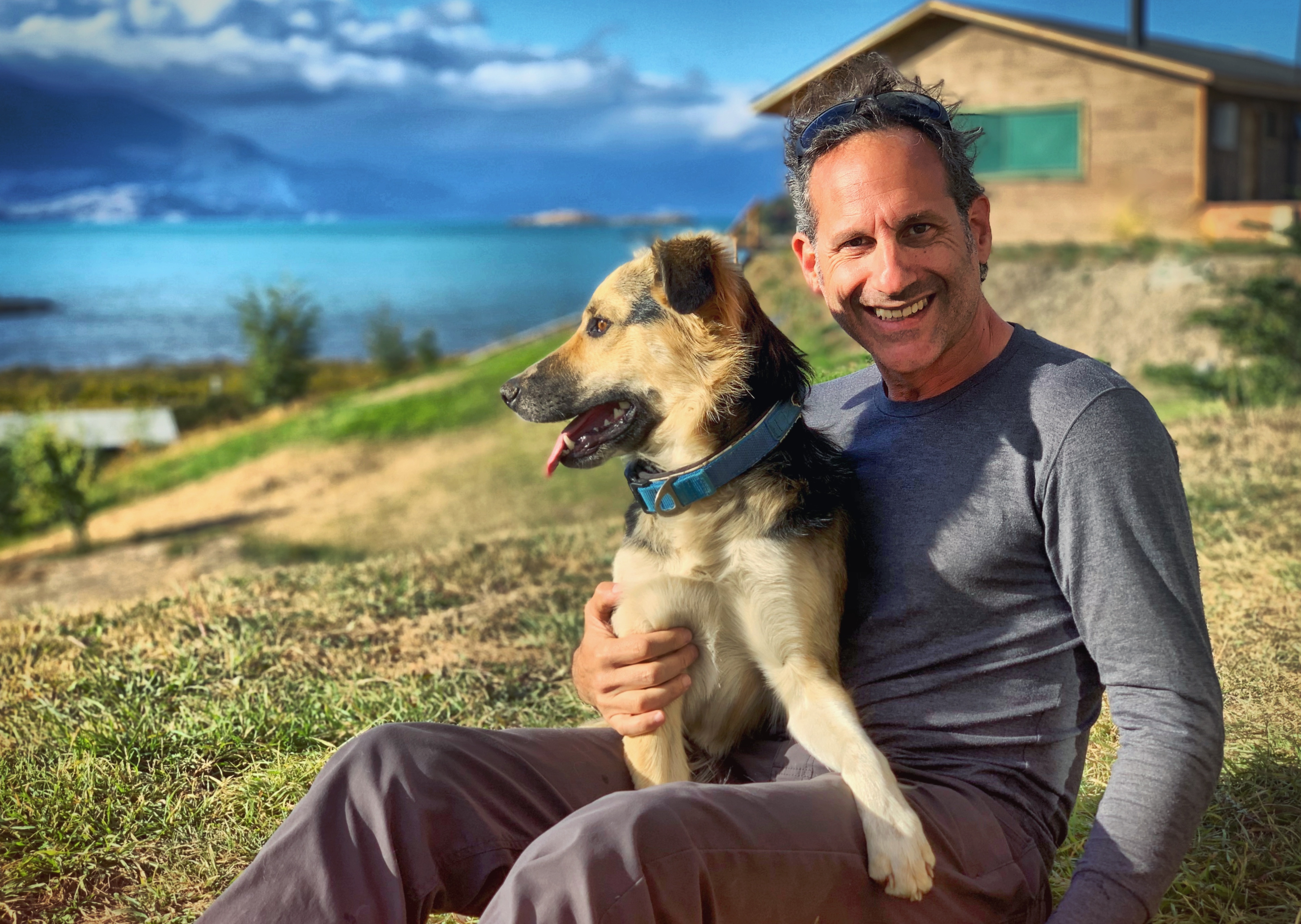 Steven with a shepherd mix, dramatic coastal view