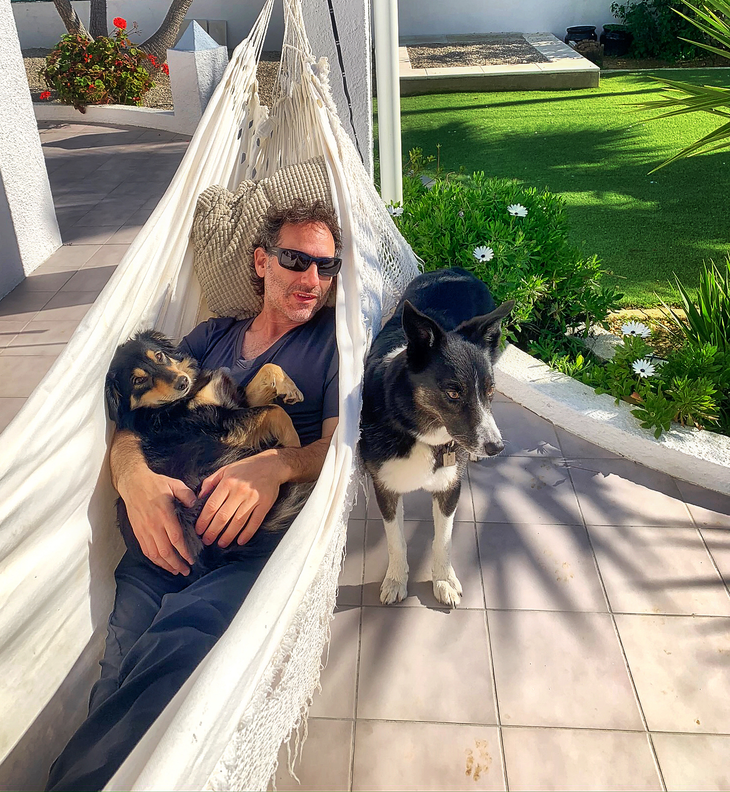 Steven in a hammock with two dogs, Portugal garden
